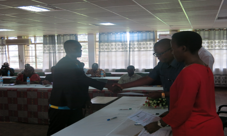 Fish farming training participants receiving a certificate from the guest of honor Dr. Anthony Sangeda 